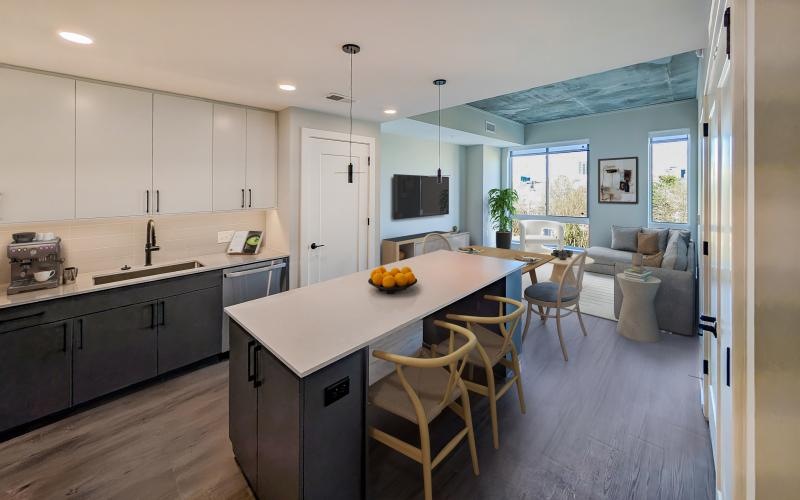 a kitchen with white cabinets and a kitchen island and chairs