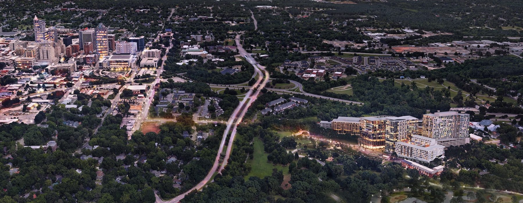 an aeriel view of a city and an apartment complex amongst several treesz