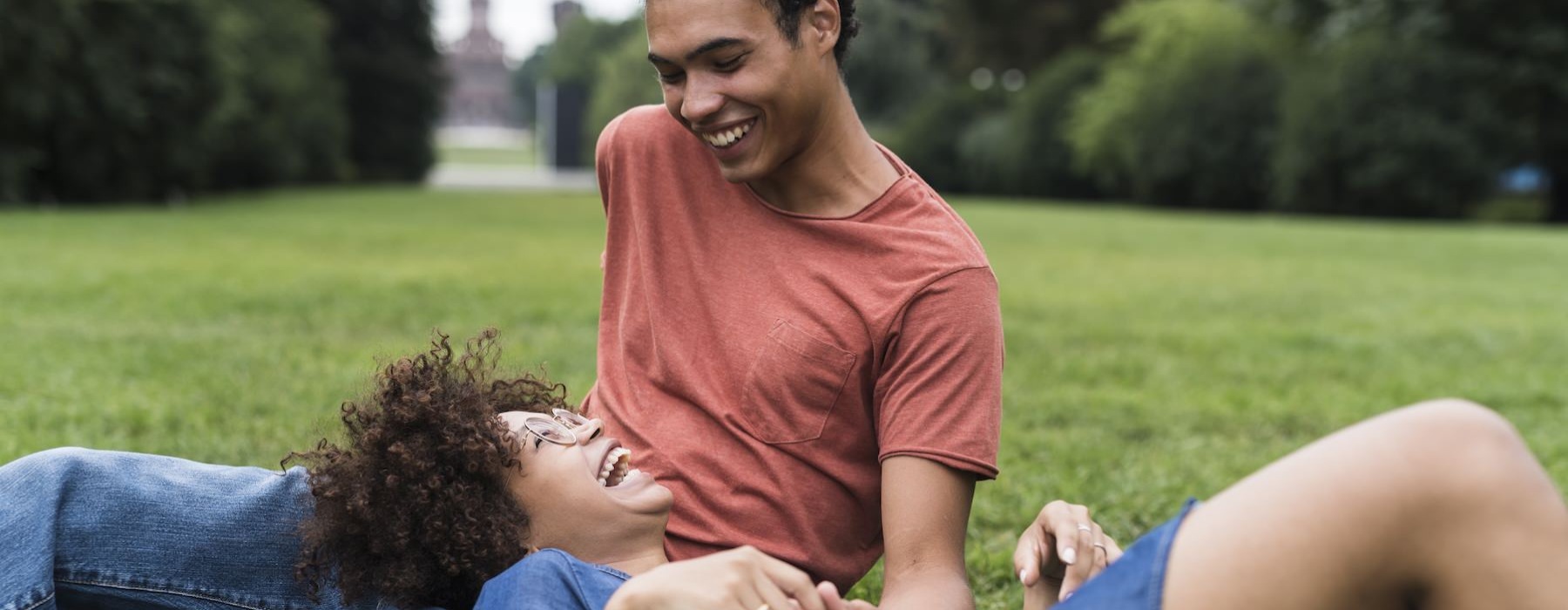 a man and a woman sitting on grass